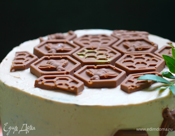 Сборка и этапы приготовления.<br />
1. Выпечь шоколадные медовые коржи. Теплые коржи поставить под вес, а также подровнять с помощью терки, если они неровные. Для сборки нам понадобиться 8 коржей, также нужны будут остатки для крошки (если будете посыпать).<br />
2. Приготовить ванильное суфле, взвесить и разделить на 3 части. Порубленный чернослив тоже разделить на 3 части.<br />
3. Приготовить сливочно-сметанный крем, взвесить и разделить на 5 частей. Порубленный грецкий орех разделить на 4 части.<br />
4. Берем неразъемное кольцо диаметром 16 см, оборачиваем дно фольгой, выкладываем внутри ацетатную пленку.<br />
5. Стряхнуть с коржей лишнюю муку кисточкой.<br />
6. Положить корж, вылить ванильное суфле и равномерно распределить кусочки чернослива.<br />
7. Положить второй корж, вылить сливочно-сметанный крем, равномерно распределив кусочки грецкого ореха. Повторить до предпоследнего коржа.<br />
8. Последний корж слегка промазываем сметанным кремом. Оставшийся крем можно отправить в холодильник, закрыв пищевой пленкой, и перед покрытием крошкой доложить. (Торт немного присядет в центре от крема, мы дополним высоту).<br />
9. Закрыть пищевой пленкой в контакт.<br />
10. Убрать в холодильник на ночь.<br />
11. Убрать фольгу, переложить на подложку, затем снять кольцо и ацетатную пленку.<br />
12. Сделать бисквитную крошку из остатков бисквита и пробить в кофемолке или блендере. 13. Подровнять крем спатулой и покрыть крошкой со всех сторон (я не украшала крошкой). Я украшала шоколадными сотами. Украсить торт ягодами или на свое усмотрение.