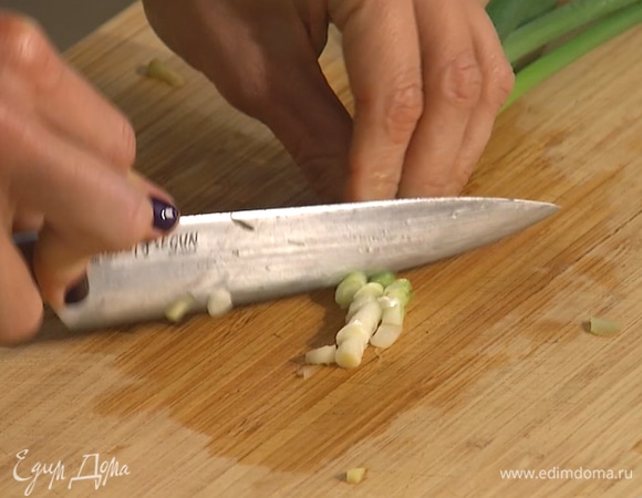 Зеленый лук нарезать, половину лука добавить к тунцу, вторую половину пересыпать в другую миску.