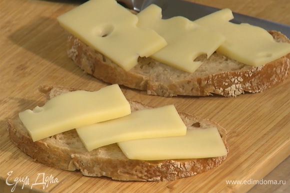 Сыр нарезать тонкими ломтиками, выложить на хлеб.