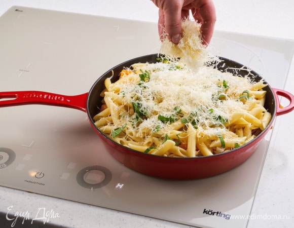 Добавьте пасту, мелко нарезанный базилик и чеснок. Перемешайте и тушите на слабом огне 2 минуты. Добавьте тертый пармезан.