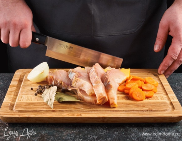 Нарежьте рыбу порционными дольками. Лук разрежьте пополам, морковь нарежьте кружочками.