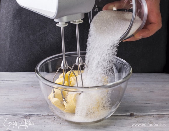 Размягченное масло с сахаром взбейте миксером.