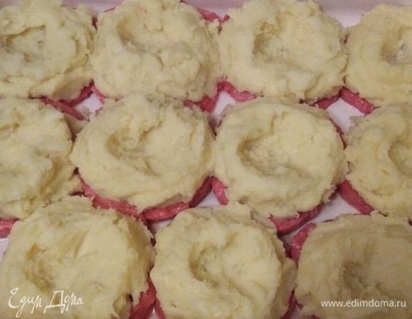 На верх фарша уложить мятый картофель. В середине сделать выемку в виде гнезда. Поставить в заранее разогретую духовку. Запекать при 190°C 25 минут.