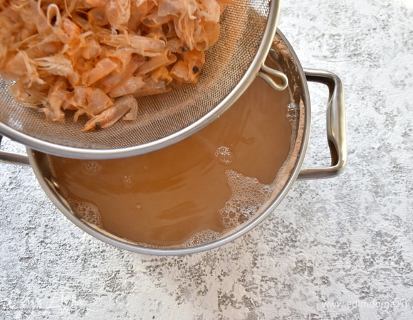 Панцири и головы залить водой и отварить в течение 15 минут. Бульон процедить.