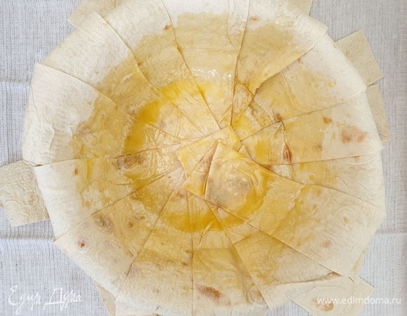 Тонкий лаваш нарезаем полосами шириной 6 см. Казан или толстостенную посуду для запекания хорошо смазываем сливочным маслом. Внахлест выкладываем полоски лаваша таким образом, чтобы края свисали. Смазываем лаваш сливочным маслом.