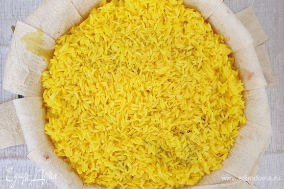 Выкладываем вторую половину риса. Оставим 2 столовые ложки растопленного масла для смазывания верха. Остальное масло равномерно распределим по рису.