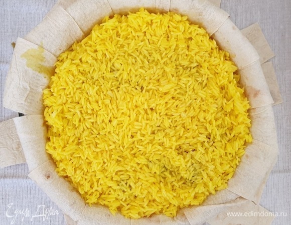 Выкладываем вторую половину риса. Оставим 2 столовые ложки растопленного масла для смазывания верха. Остальное масло равномерно распределим по рису.