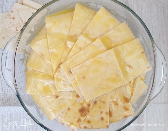 Закрываем рис свисающими полосками лаваша. Лишнее обрезаем. Смазываем лаваш двумя столовыми ложками масла.