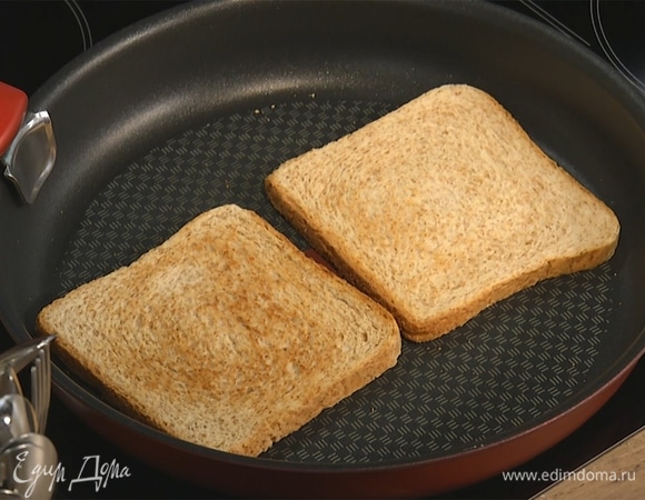 На сухой сковороде подсушить хлеб с двух сторон до образования золотистой корочки. Выложить на тарелку, смазать сливочным маслом.  