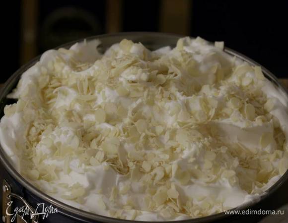 На выпеченный горячий корж выложить в один слой нарезанные сливы, сверху выложить взбитые белки, разровнять и присыпать миндальными хлопьями.