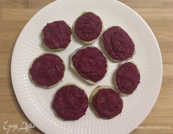 Картофель очистить и нарезать кружками толщиной 1 см. Положить на каждый картофельный кружок по 1 ч. л. свекольного пюре.