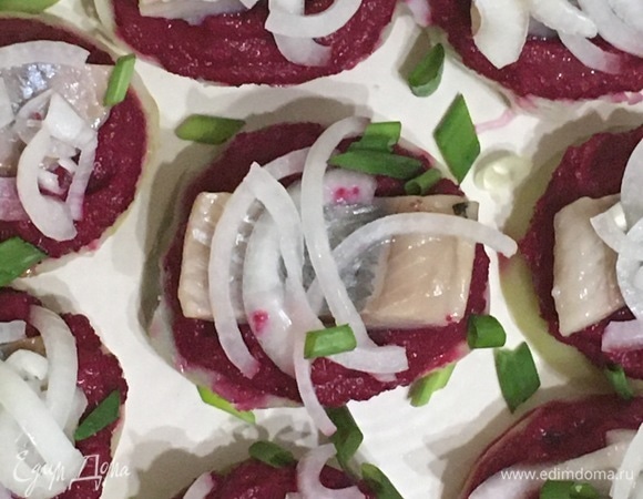 Филе сельди нарезать кусочками. Сверху уложить по кусочку сельди. Украсить маринованным луком.