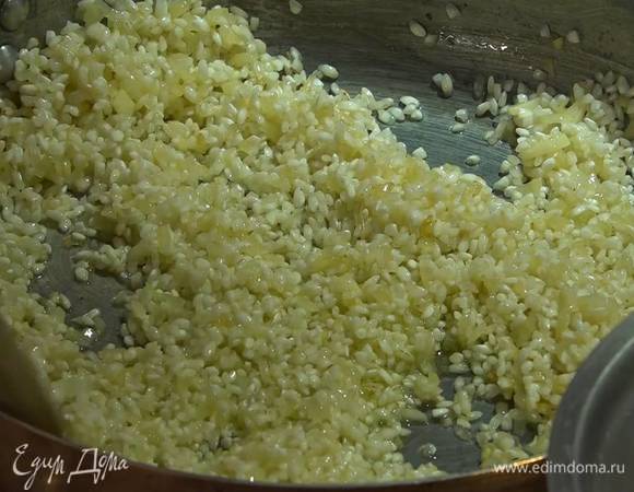 Всыпать в сковороду рис и сделать тостатуру: постоянно помешивая, прогревать в течение 1‒2 минут, пока зерна не станут прозрачными.