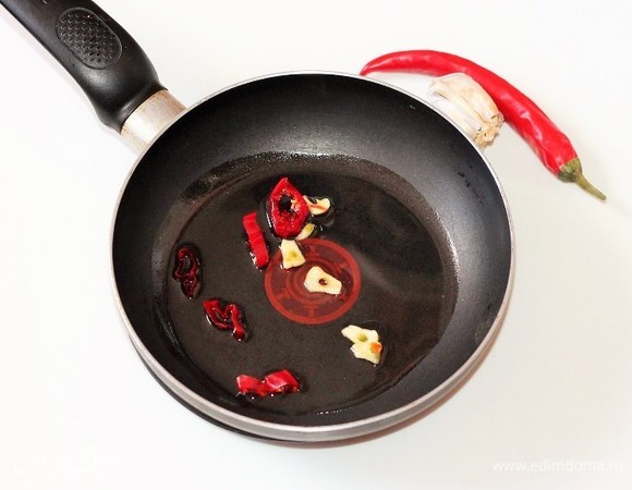 На разогретом оливковом масле обжариваем нарезанные перчик чили и чеснок. Затем овощи удаляем, масло оставляем.