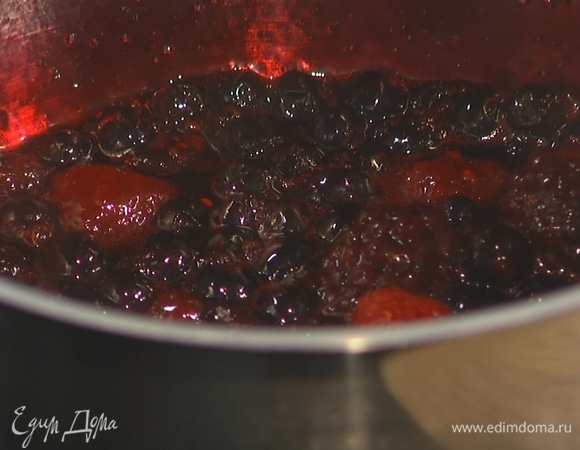 В сотейник всыпать замороженные ягоды, добавить ликер и сахар. Потомить ягоды на среднем огне в течение 5 минут. Затем снять с плиты и дать остыть.