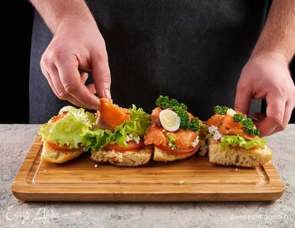 Сверху выложите лист салата, рыбу, яйцо. Украсьте петрушкой.