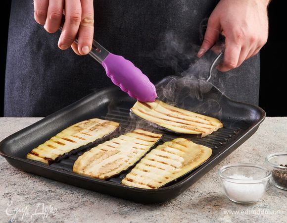 Баклажаны нарежьте вдоль тонкими полосками. Посолите, поперчите и обжарьте на сковороде-гриль с двух сторон.