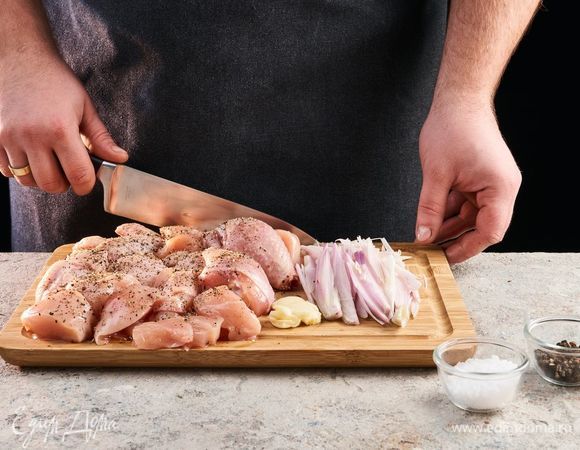 Разделайте курицу, посолите, поперчите. Нарежьте лук слайсами, чеснок порубите.