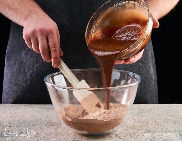 Постепенно влейте эту смесь в сухие ингредиенты и вымесите густое тесто.