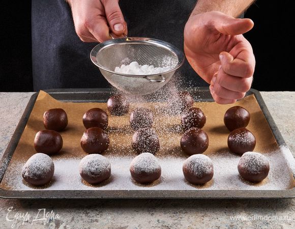 Из теста сформируйте шарики размером с грецкий орех и посыпьте их сахарной пудрой. Выложите шарики на противень, застеленный пергаментной бумагой, с промежутком 2–3 см между шариками. Поставьте в духовку, разогретую до 180°C, и выпекайте 12 минут.