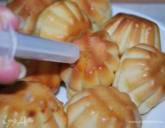 Пропитайте выпечку, пока она не остыла. Можно наколоть зубочисткой или с помощью шприца. Переложите в глубокую миску и полейте их пропиткой, дайти им полностью впитаться. Пропитанные ромовые бабы можно хранить в закрытой банке  в холодильнике, с ними ничего не будет. Они не раскиснут (за счет такого теста) и не испортятся (за счет алкоголя).