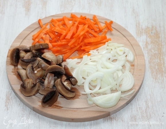 Приготовим начинку. Очищаем морковь и репчатый лук. Морковь нарезаем соломкой, лук — полукольцами. Грибы нарезаем пластинами.