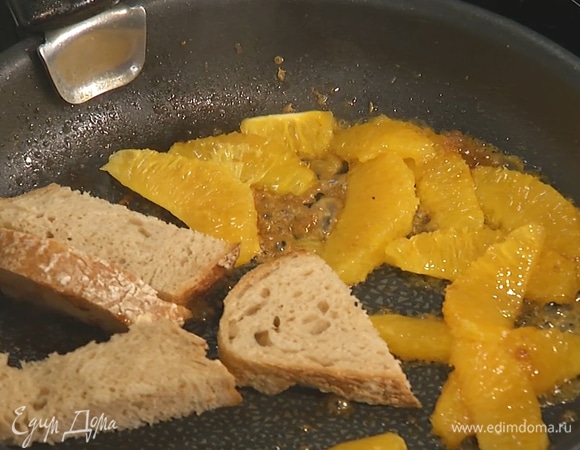 Хлеб нарезать небольшими кусками, добавить в сковороду к апельсинам, слегка обжарить.