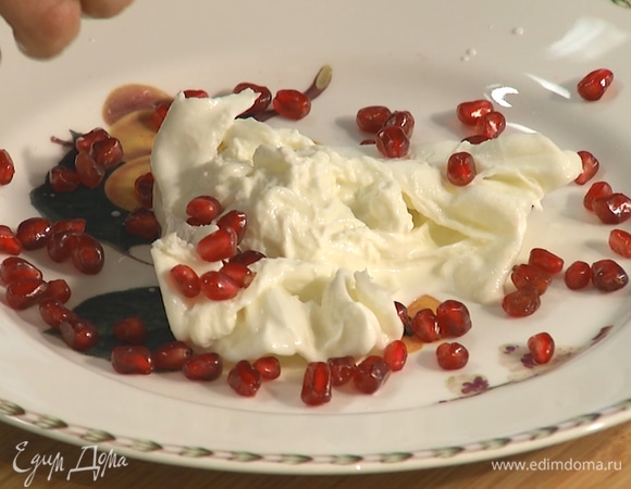 На тарелку выложить сыр буррата, разделить на части, посыпать зернами граната.