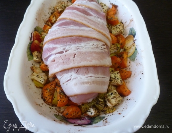 Запеленать филе в сырокопченый бекон. Достать форму из духовки, убрать фольгу и положить сверху филе, завернутое в бекон. 