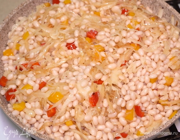 Отправляем на сковороду раннее отваренную фасоль и перемешиваем все ингредиенты.