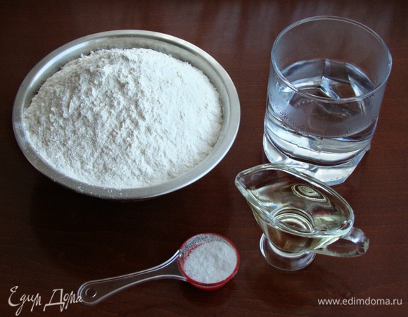 В миску с просеянной мукой всыпать щепотку соли и влить растительное масло. Затем влить кипяток и лопаточкой (тесто очень горячее) замесить тесто.