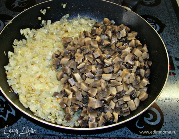 Обжарить на растительном масле мелко нашинкованный репчатый лук. К обжаренному луку добавить мелко нашинкованные грибы, посолить, поперчить и обжарить.