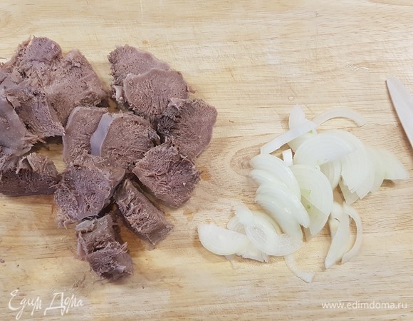 Отваренный язык нарезать на кусочки толщиной 1,5 см. Лук нарезать полукольцами.