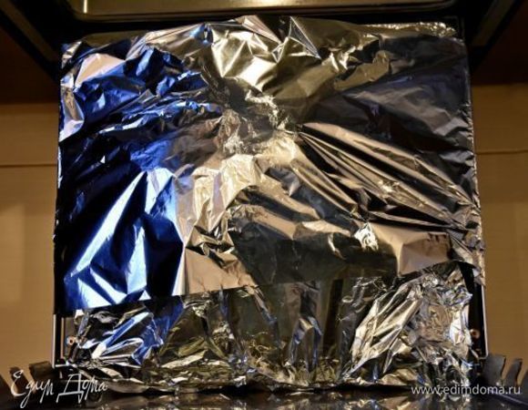 Духовку разогреть до 200°C. Соорудить конструкцию из противня, в который влить 1 стакан воды. На противень установить решетку и уложить подготовленную утку грудкой вверх. Всю конструкцию накрыть фольгой и отправить запекаться на 1,5 часа.