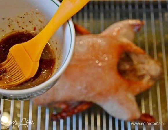 Для маринада, который и придаст утке лаковую блестящую корочку, смешать кунжутное масло, соевый соус, порошок имбиря и смесь свежемолотых перцев. Освободить птицу от фольги и с помощью силиконовой кисточки нанести маринад. Увеличить температуру в духовке до 250°C и запекать еще 20 минут. В оставшийся маринад добавить 1 ст. л. меда и снова нанести его на утку. Подключить функцию «Гриль» на 10 минут. В течение последних 30 минут  перевернуть утку однократно, чтобы она равномерно покрылась аппетитной корочкой.