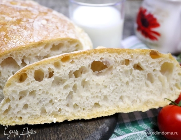 Достать хлеб, «умыть» его водой, прикрыть полотенцем и оставить на решетке остывать хотя бы на полчаса. Только потом его можно разрезать. Корочка тонкая, хрустящая. Мякиш пузырчатый, эластичный. Если его смять, то он с легкостью распрямляется. Хлебушек не влажный и не сухой, дрожжами не пахнет, вкус настолько сбалансирован, что придраться не к чему. Муж любит черный хлеб, но этот белый ему очень нравится.