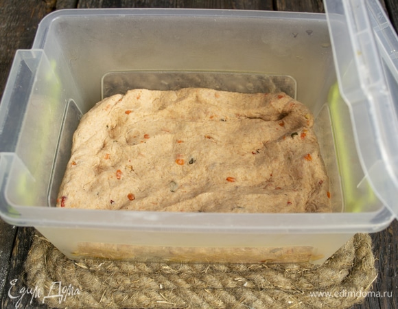 Контейнер смазываем оливковым маслом, кладем тесто, закрываем плотно, оставляем при комнатной температуре на 1 час 30 минут.