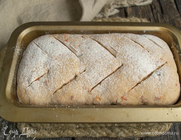 Поднявшуюся буханку посыпаем мукой, делаем небольшие косые надрезы острым ножом.