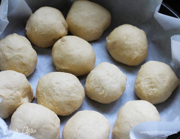 Взять круглую форму (24 см — идеально), смазать маслом или выстелить бумагой для выпечки. Разделить тесто на 12 частей. Сформировать булочки. Выложить в форму не очень плотно друг к другу (по типу булочек «Дружная семейка»).