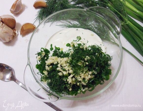 Пока картошка варится, есть время приготовить сметанный соус. Для этого измельчаем зелень укропа и зубчики чеснока, перемешиваем все со сметаной. В соус можно добавить свои любимые приправы.