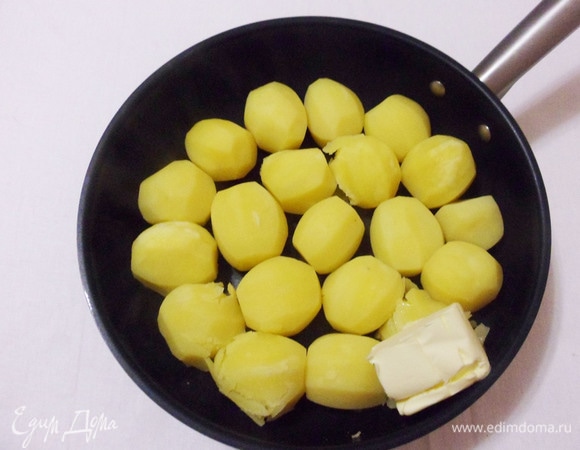 По готовности картошки осторожно сливаем воду. Добавляем в сковороду сливочное масло и обжариваем картошку на среднем огне до золотистой корочки в течение 5 минут.