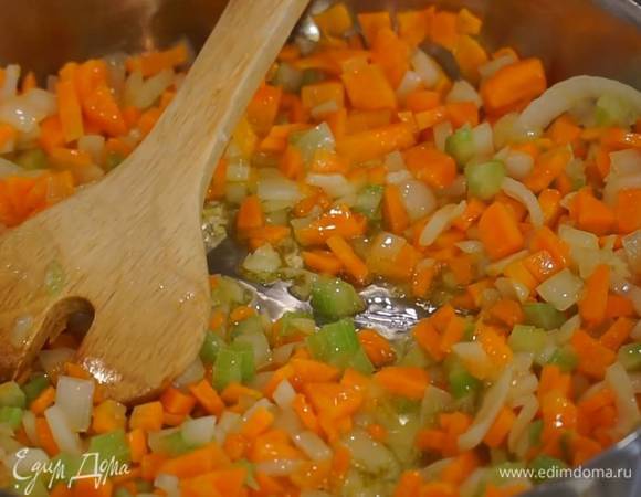 Разогреть в сковороде 2 ст. ложки оливкового масла и обжарить морковь и сельдерей на маленьком огне, затем добавить лук, все перемешать.
