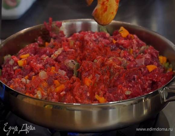Фарш небольшими порциями выкладывать к овощам с панчеттой, каждый раз вымешивая лопаткой, затем добавить томатную пасту и все перемешать.
