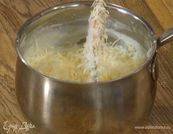 В сотейник, в котором прогревалось молоко, выложить 50 г сливочного масла, всыпать муку и, помешивая, заварить, затем, продолжая перемешивать, тонкой струйкой влить молоко. Когда вся масса заварится, снять сотейник с огня, всыпать большую часть натертого сыра и вымешать.