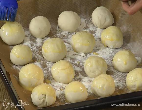 Яйцо слегка взбить и смазать булочки.