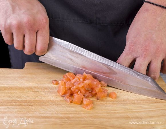 Копченую красную рыбу нарежьте маленькими кусочками.
