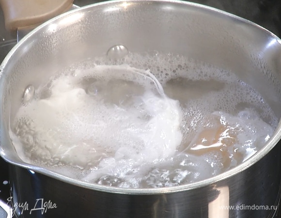 В небольшую емкость разбить яйцо так, чтобы не повредить белок и желток. В кипящей воде с помощью венчика создать воронку, в нее аккуратно влить яйцо. Таким же образом влить второе. Уменьшить температуру воды, отварить до готовности.