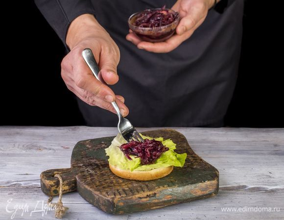 Положите салатный лист, затем — половину лука.