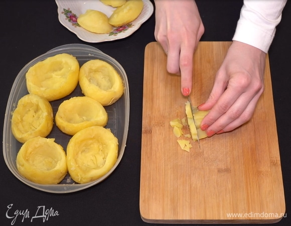Картофель я заранее промываю и отвариваю в мундире. Затем опускаю в холодную воду и очищаю от кожицы. Нужно аккуратно достать из середины картофеля часть мякоти и освободить место для начинки. Мякоть нам понадобится для зажарки. Нарезаем ее мелкими кубиками.  