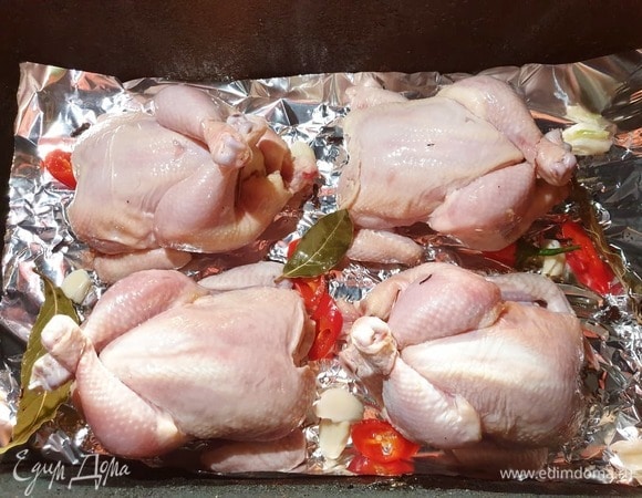 На решетку коптильни выкладываем фольгу, делаем в ней несколько проколов. Сверху укладываем цыплят и коптим в течение 40–50 минут. Если запекаете в духовке, противень с цыплятами ставим в предварительно разогретую до 200°C духовку на 35–40 минут.